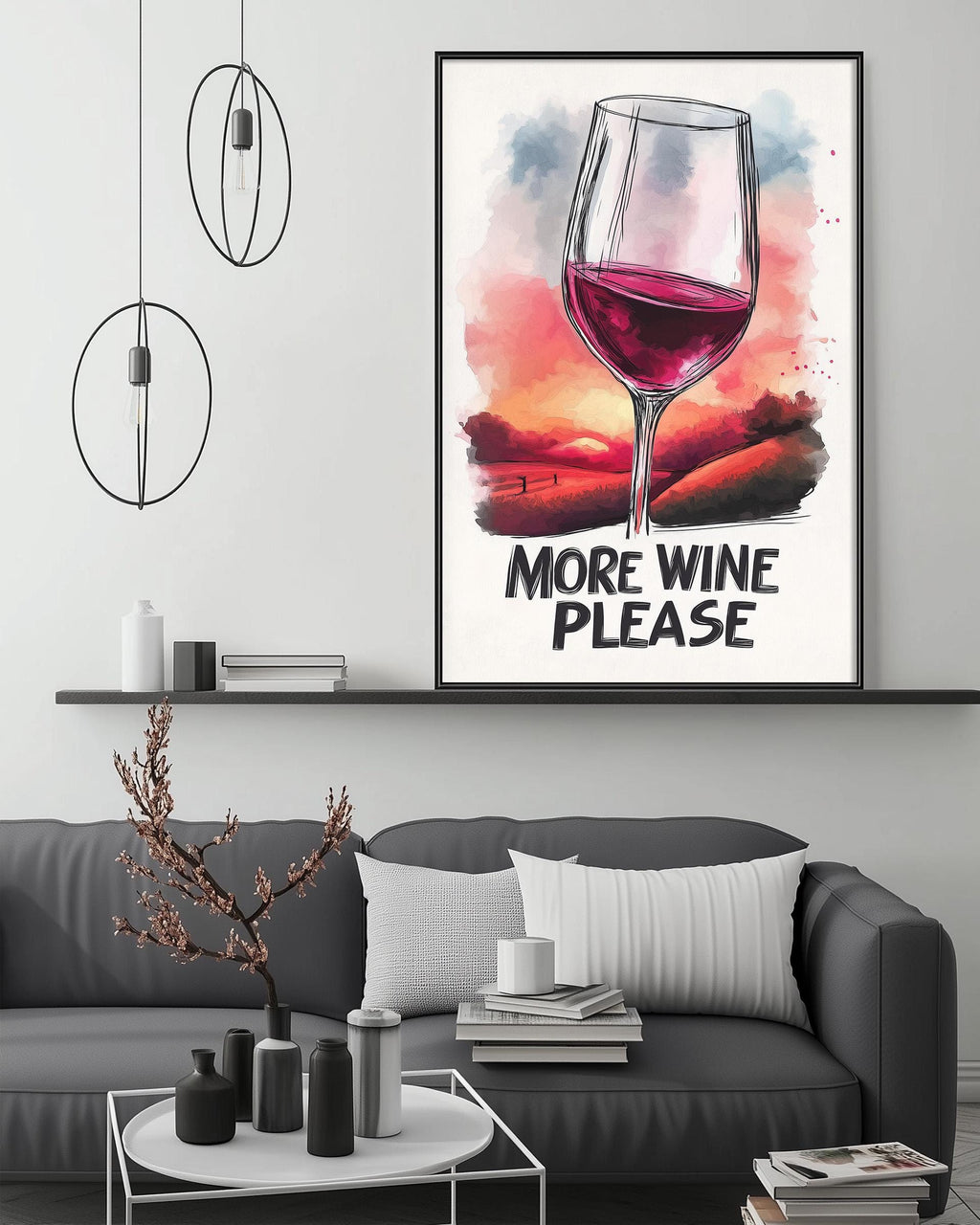 a large framed poster with a wine glass and a sunset in the background, hanging on a wall above a gray couch with a coffee table in front of it.