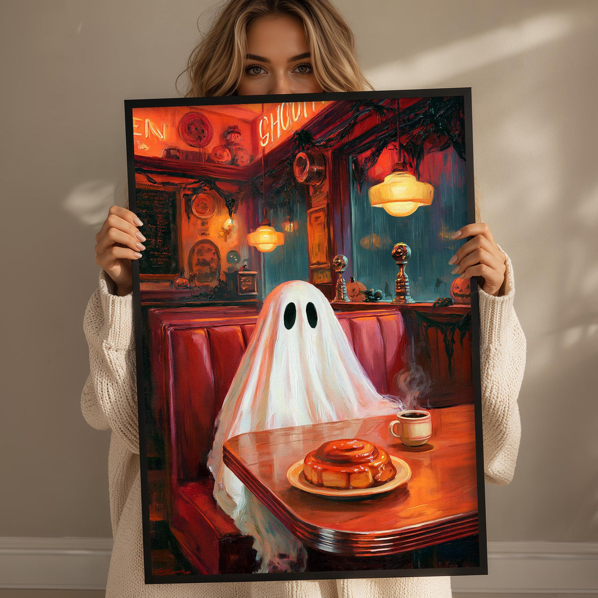 A woman holds up a framed painting depicting a ghost sitting at a table with a plate of food, including a donut, in a restaurant setting.