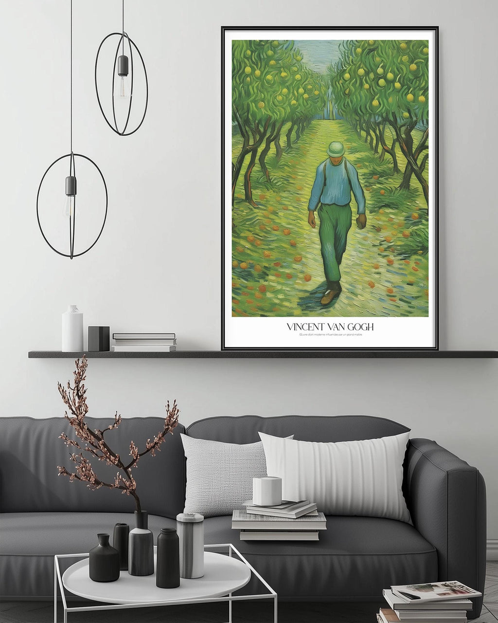 a large painting of a man walking through a lush, green orchard, with a black frame and a white border. The painting is hung on a wall above a gray couch, which has a coffee table in front of it. The room also contains a shelf with various decorative items, and a potted plant on the floor.