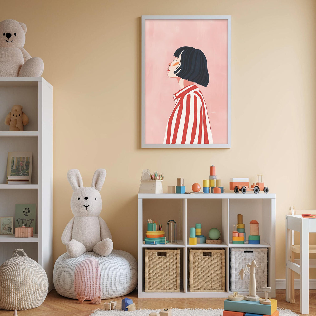 A child's bedroom with a pink wall, a framed illustration of a woman, a white bookshelf, a stuffed rabbit, and a toy train set.