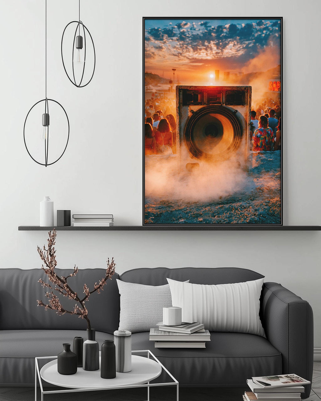 a large framed picture hanging on a wall above a gray couch in a living room setting.