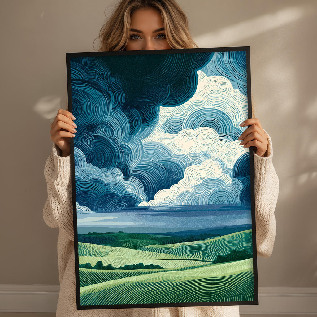A woman holding a framed print of a landscape with rolling hills and a cloudy sky.