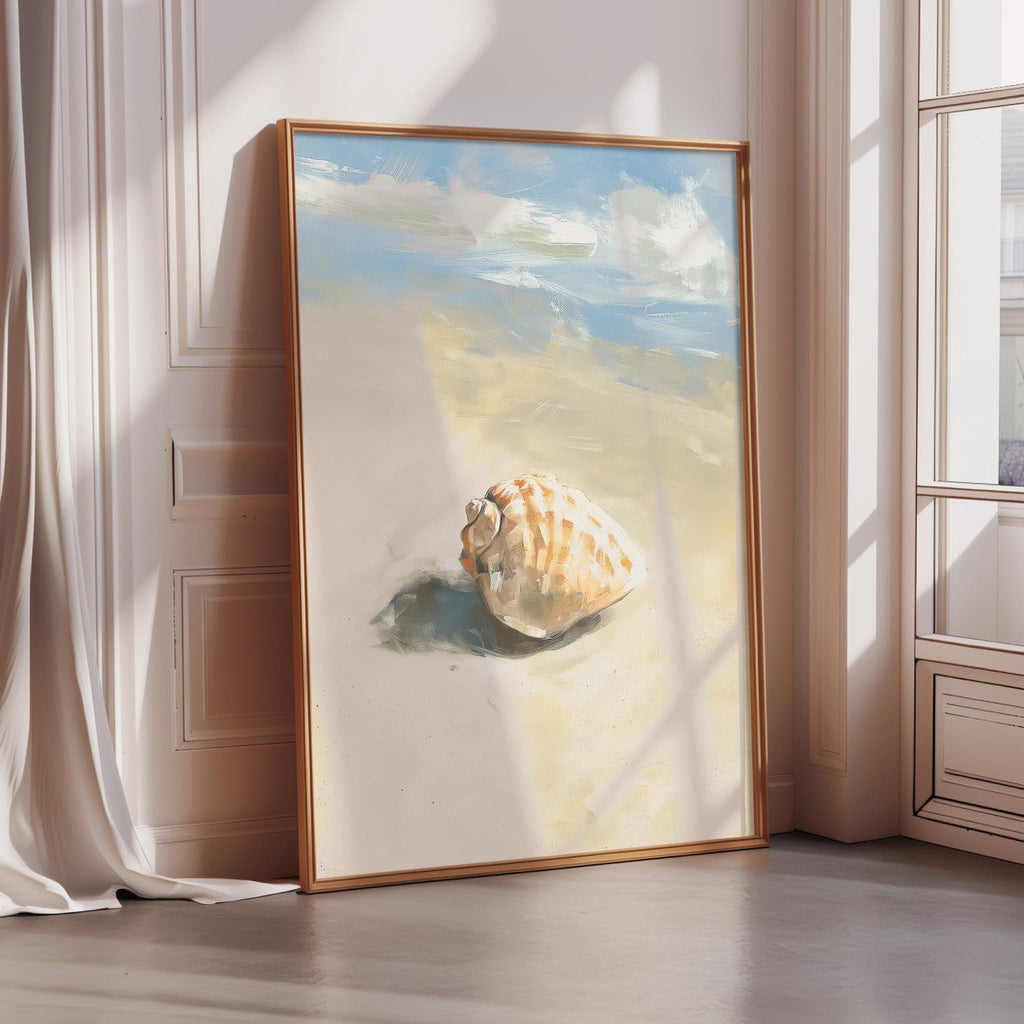 A framed painting depicting a seashell on a sandy beach, with a blue sky and clouds in the background.