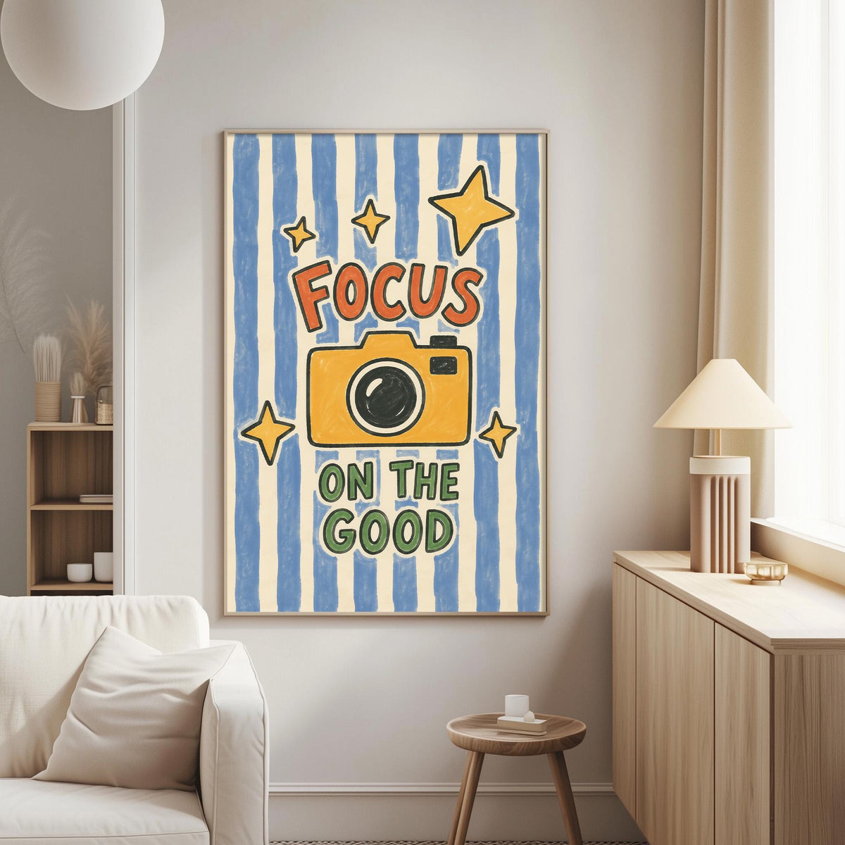 a living room with a large framed poster on the wall that says "Focus on the good".