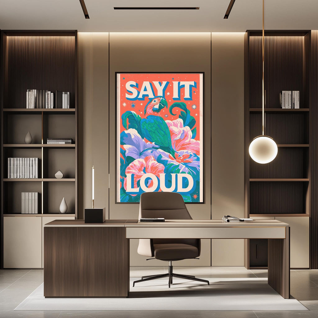 a modern office space with a large, colorful poster on the wall that says "SAY IT LOUD". The office has a wooden desk, a chair, and a bookshelf filled with books. The overall design and decor create a professional and vibrant atmosphere.