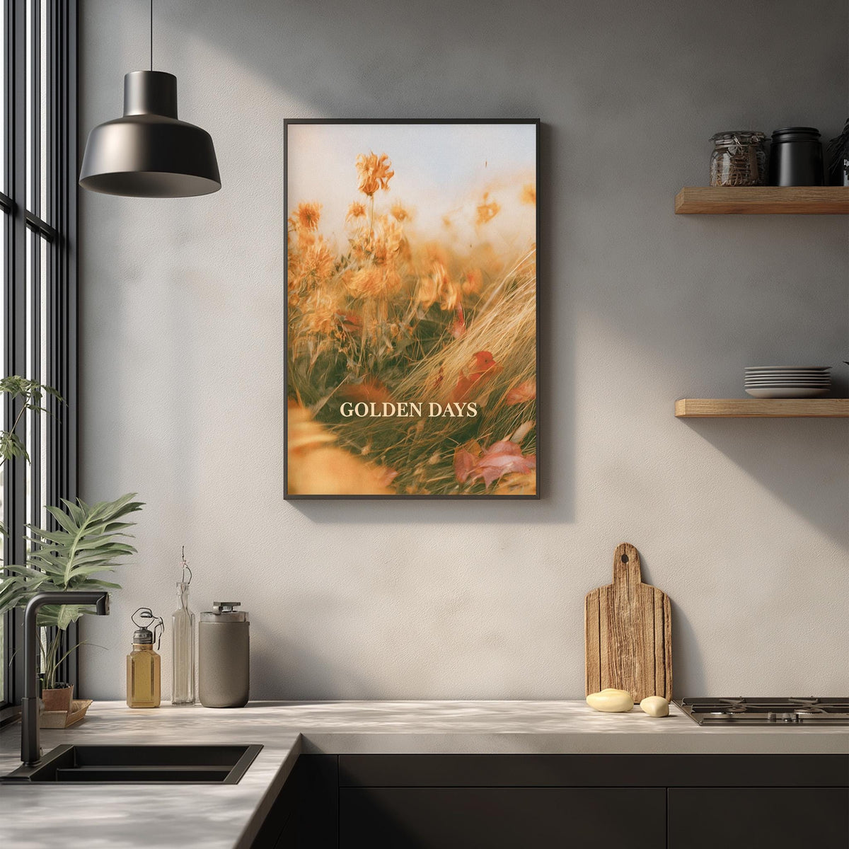a kitchen counter with a framed picture of a field of flowers hanging above it. The picture has a warm, golden hue and the text "GOLDEN DAYS" is visible. The kitchen counter also has various items such as a cutting board, a soap dispenser, and a plant.