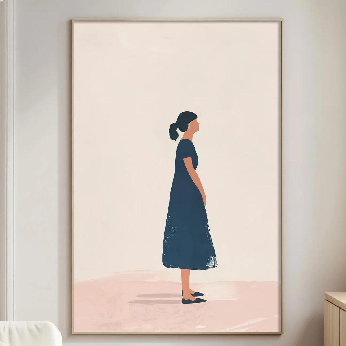a living room with a large framed artwork of a woman in a blue dress hanging on the wall. The room has a white sofa, a wooden side table, and a lamp on a nearby table.