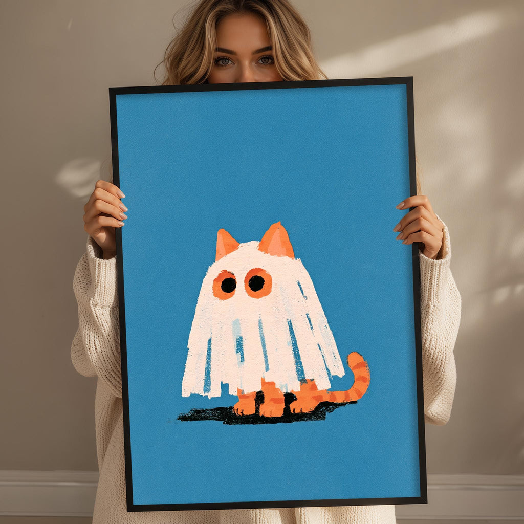 A woman is holding up a framed picture of a ghost cat with a blue background.