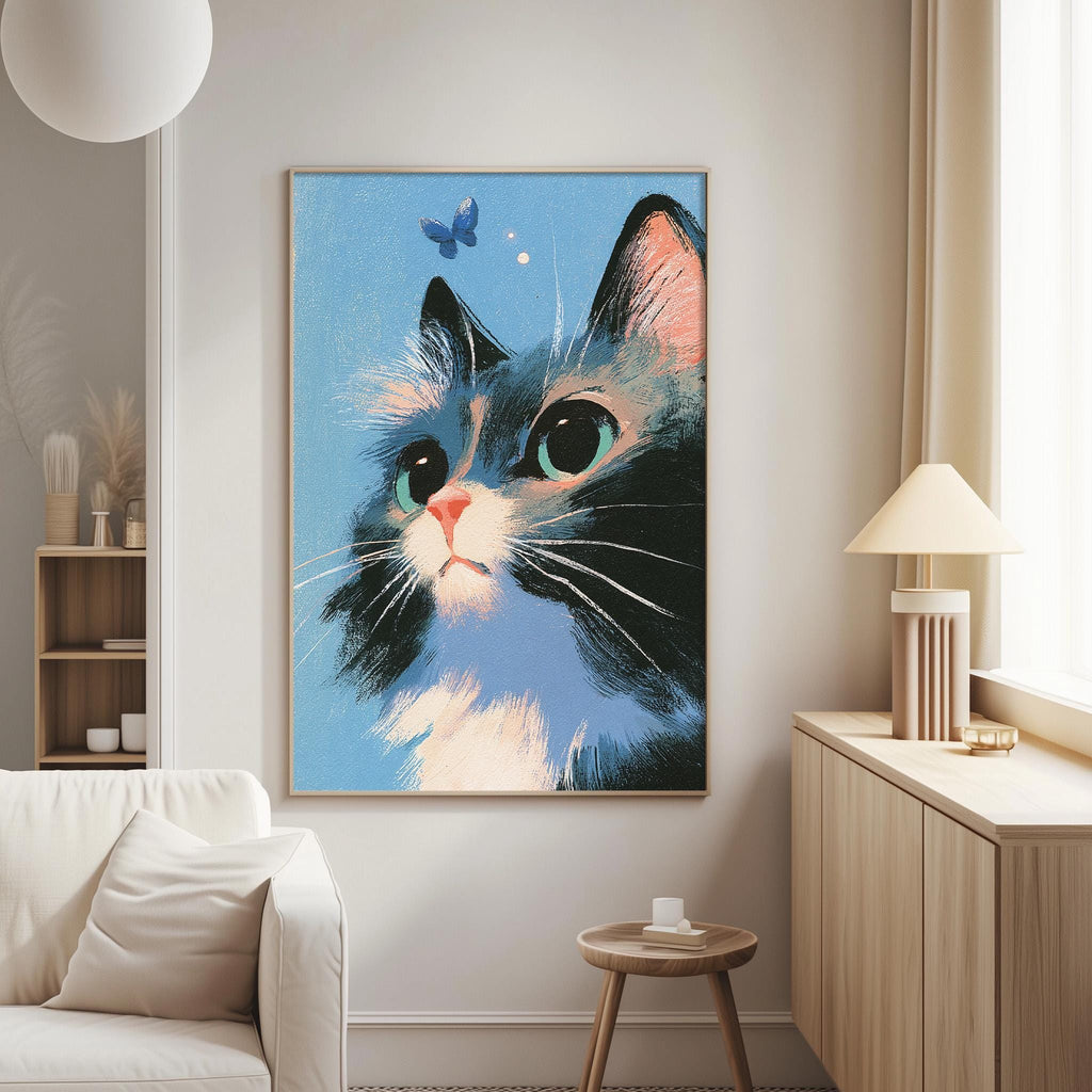 a large framed painting of a cat with a blue background and a butterfly in the top right corner. The painting is hanging on a wall in a living room setting, with a white couch and a small table nearby.