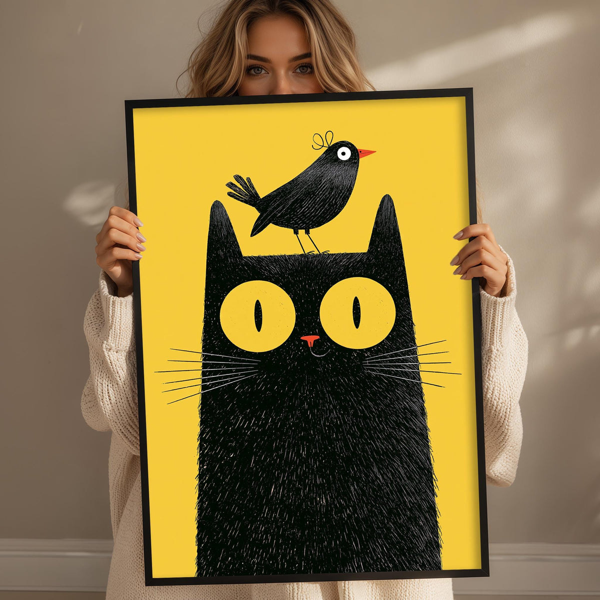 A woman is holding up a framed picture of a black cat with a bird perched on its head.