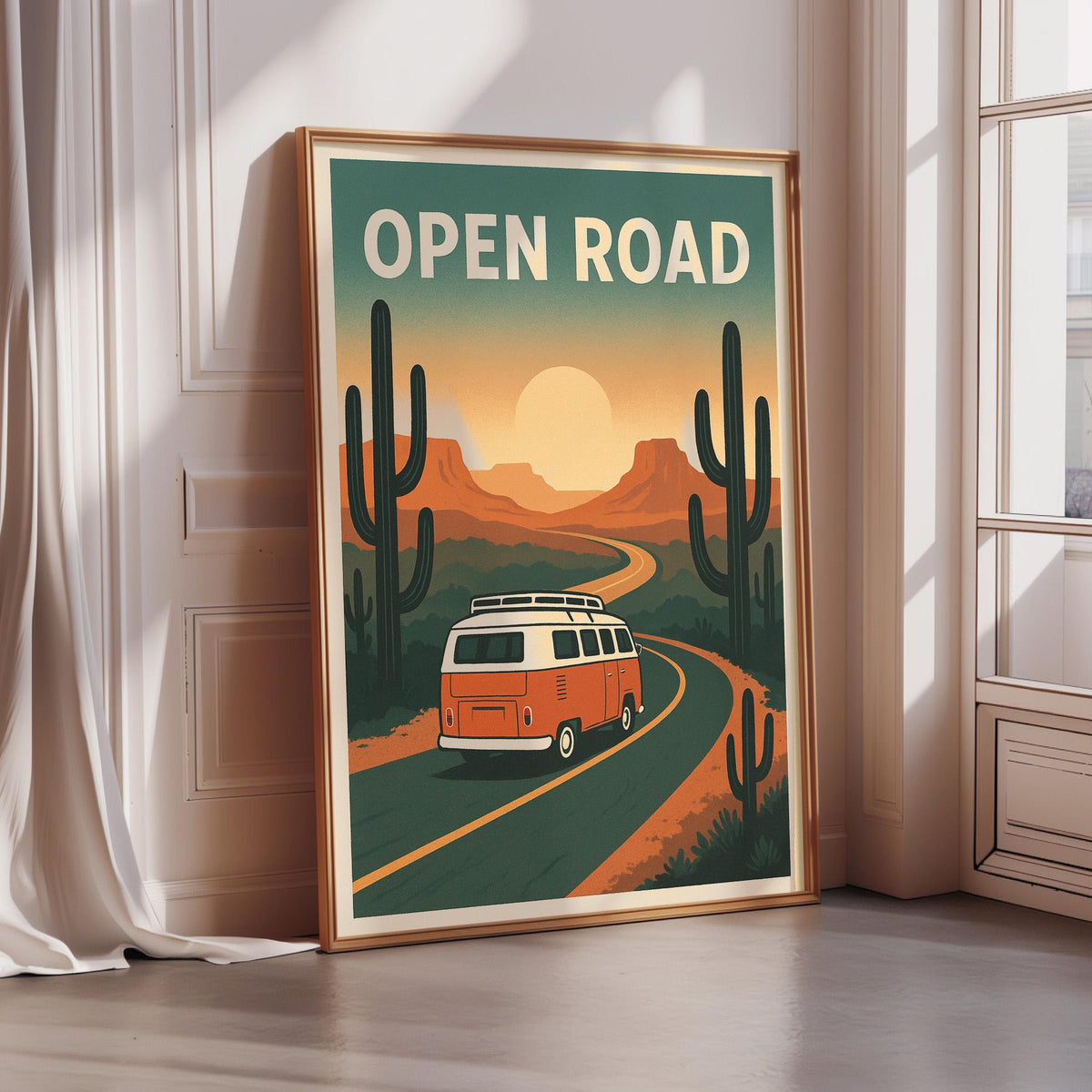 a framed poster with a vintage-style illustration of a van driving down a road surrounded by desert scenery, with cacti and mountains in the background.