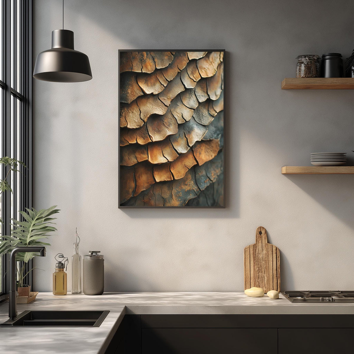 a kitchen counter with various kitchen items, including a cutting board, a soap dish, and a potted plant. Above the counter, there is a framed picture hanging on the wall, depicting a pattern of orange and brown leaves or bark.