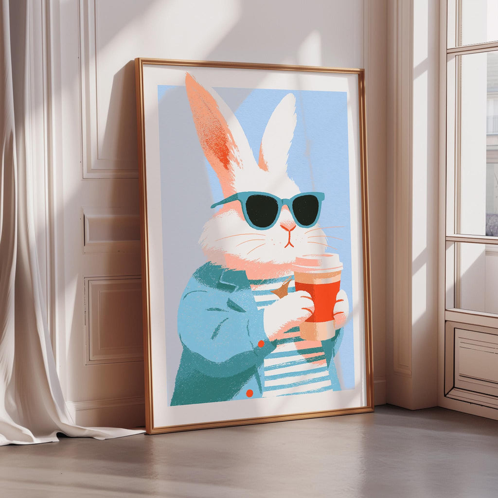 A framed illustration of a white rabbit wearing sunglasses and holding a coffee cup.