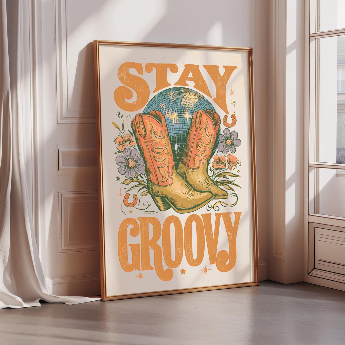 A framed poster with the text "STAY GROOVY" and an illustration of a pair of cowboy boots, a disco ball, and flowers.