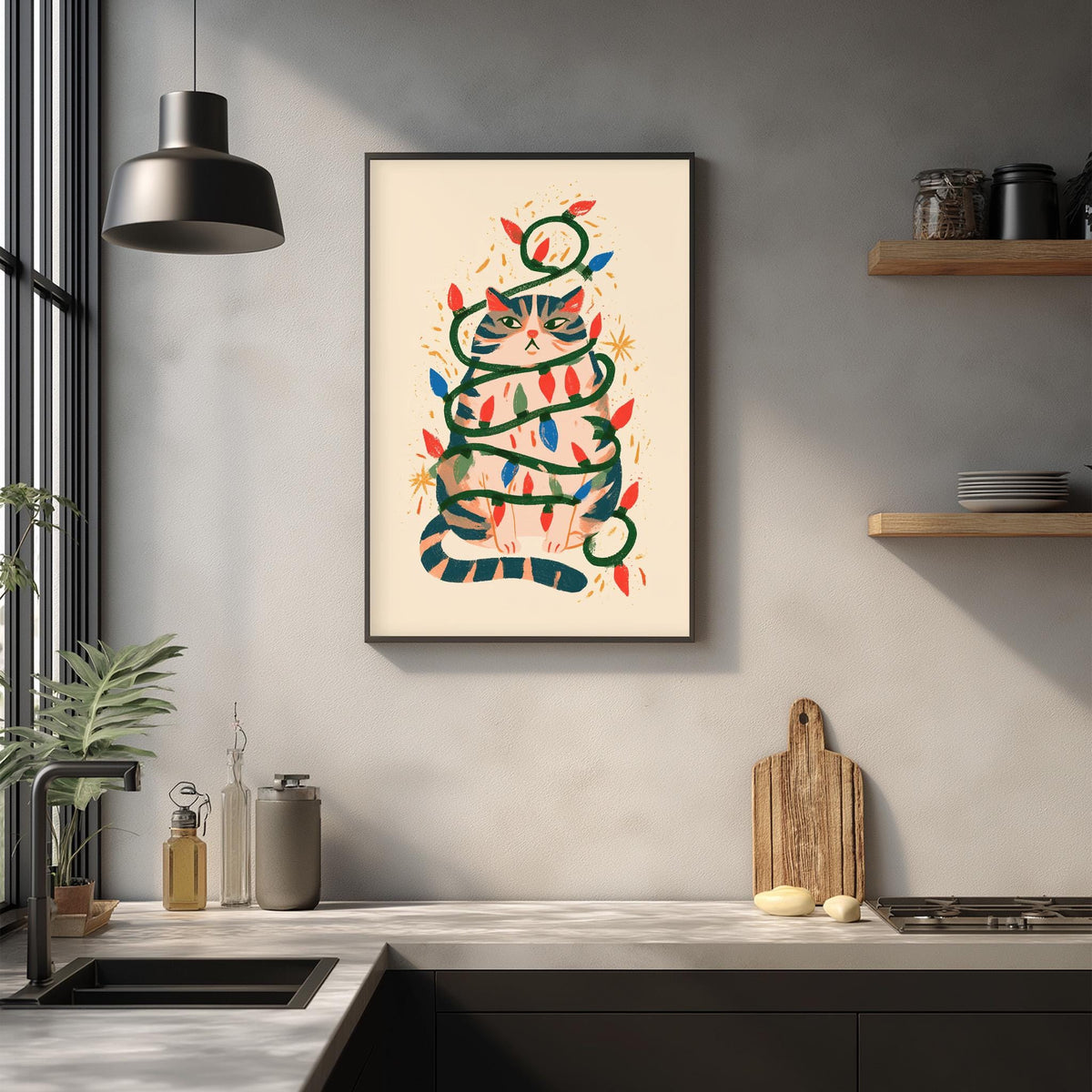 a kitchen counter with various items on it, including a framed picture of a cat wrapped in Christmas lights, a wooden cutting board, and a potted plant.