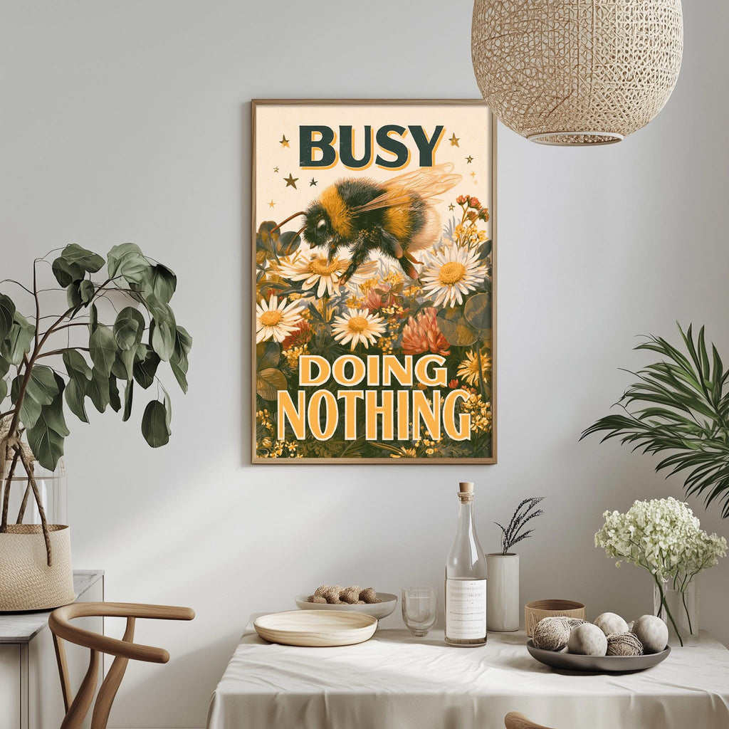 a framed poster with a bee and flowers hanging on a wall, surrounded by various decorative elements such as plants, a table, and a bowl.