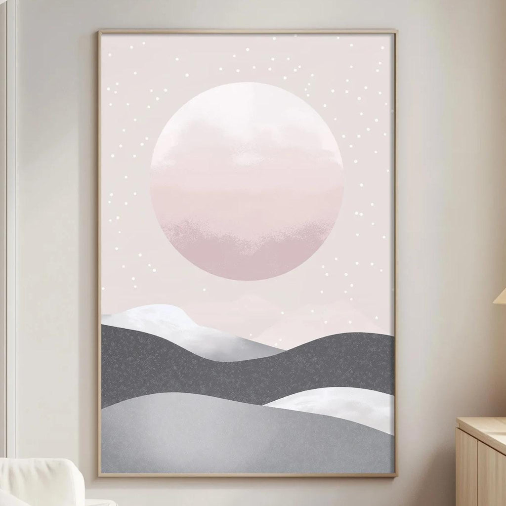 a living room with a large framed poster of a mountain landscape hanging on the wall. The poster has a pink and gray color scheme, and it appears to depict a serene mountain scene with a large moon in the sky. The room also includes a white sofa, a wooden side table, and a lamp on a nearby table.