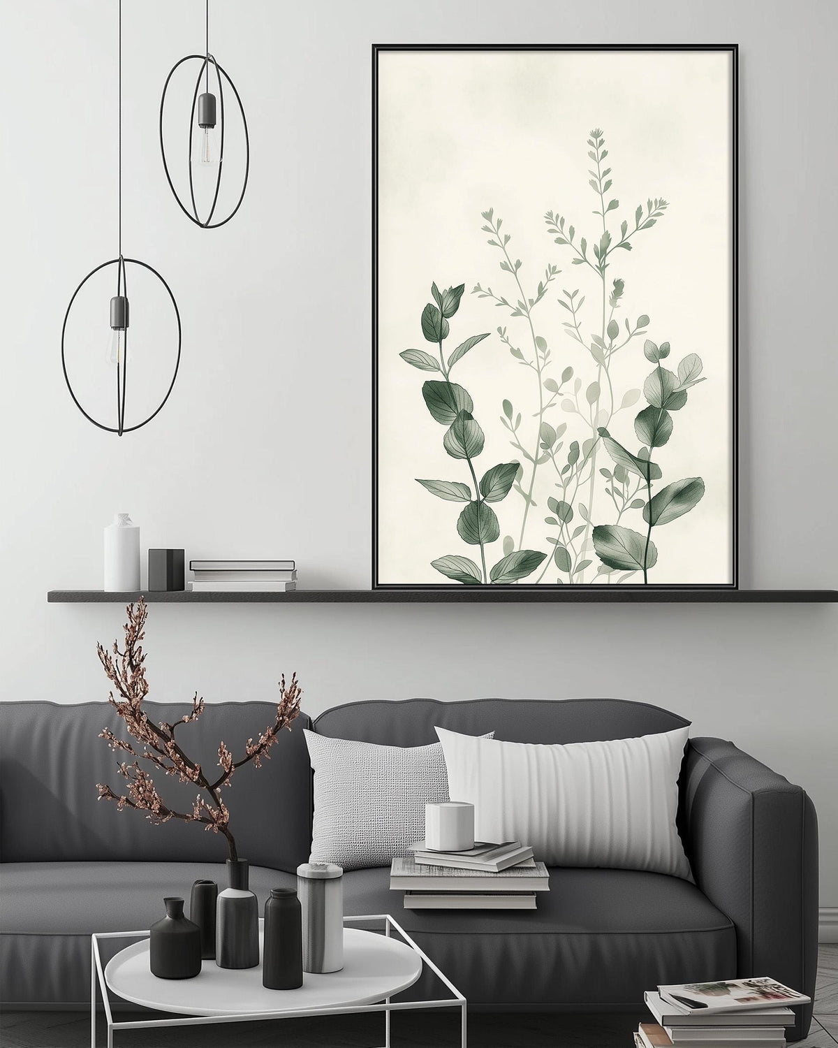 a modern living room with a gray sofa, a coffee table, and a large framed print of green leaves on the wall above the sofa.