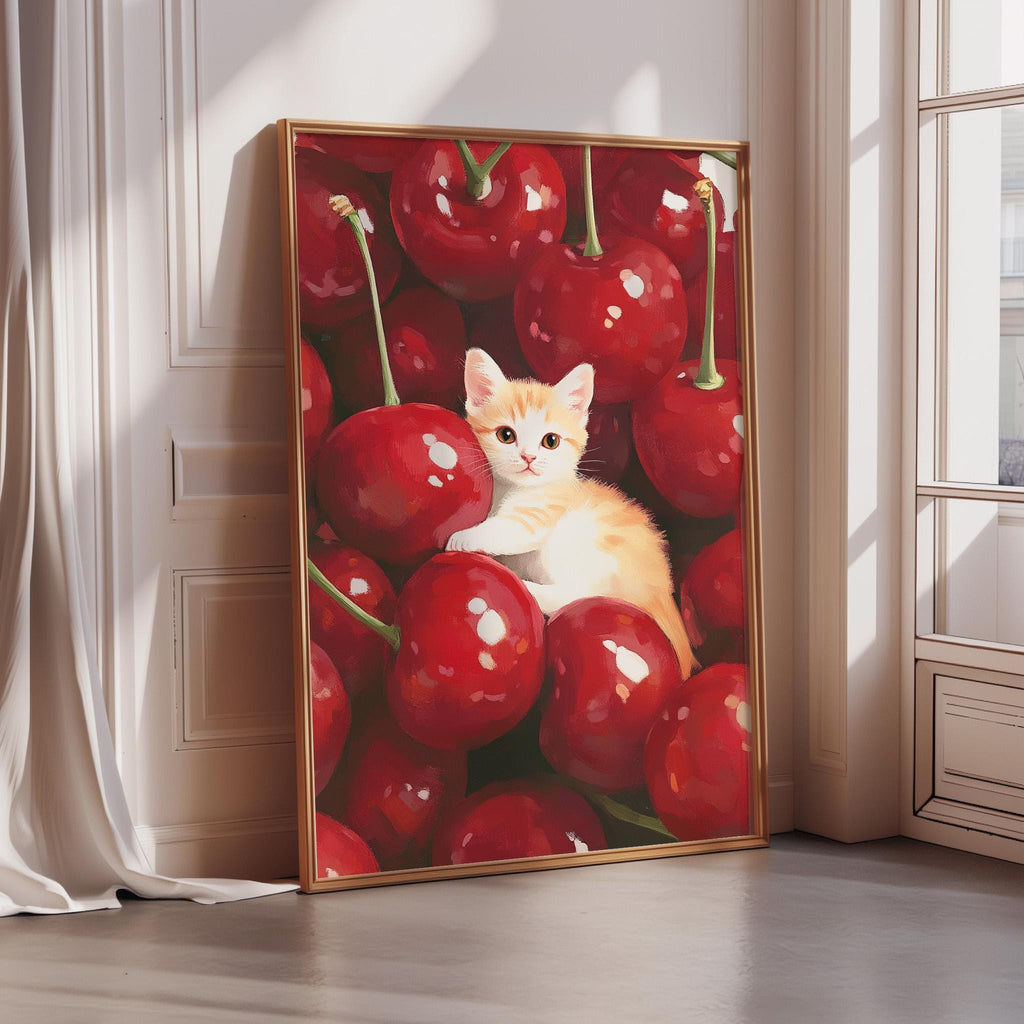 A framed painting depicting a small orange and white cat sitting among a pile of red cherries.