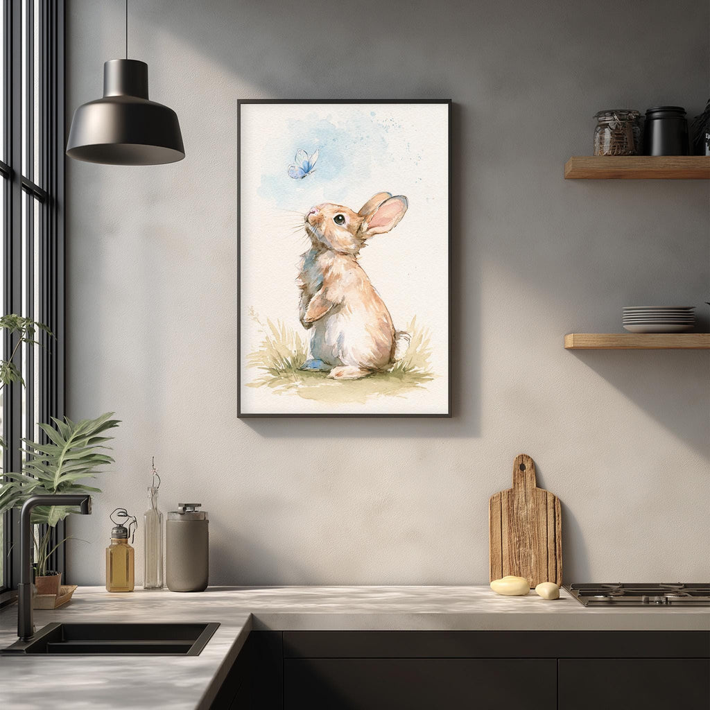 a framed painting of a rabbit sitting on the ground, looking up at a butterfly, hanging on a wall above a kitchen counter.