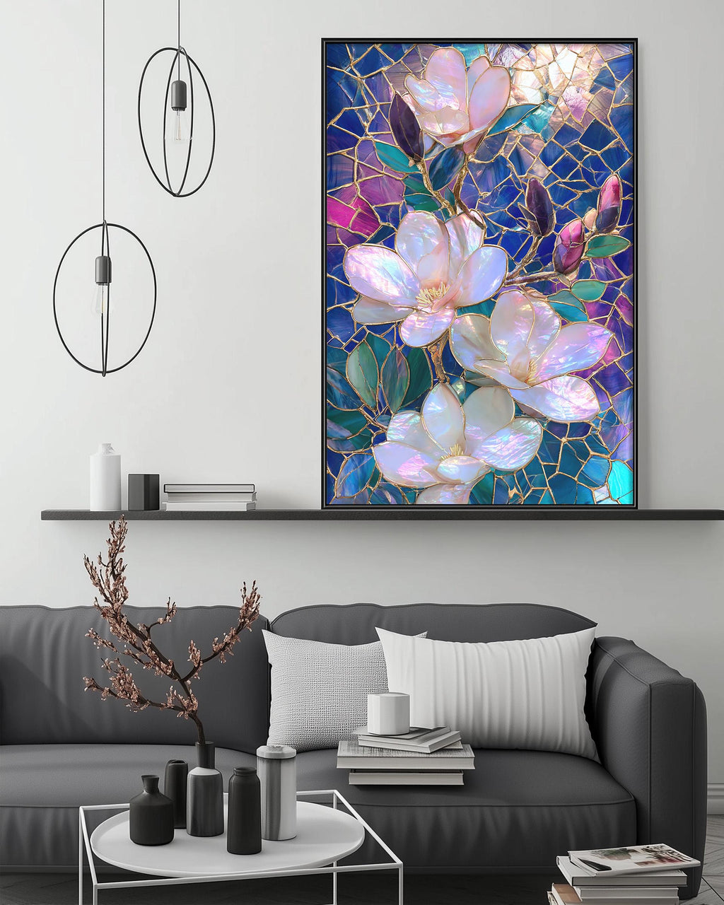a large framed painting of pink and white flowers on a wall above a gray couch in a living room setting.