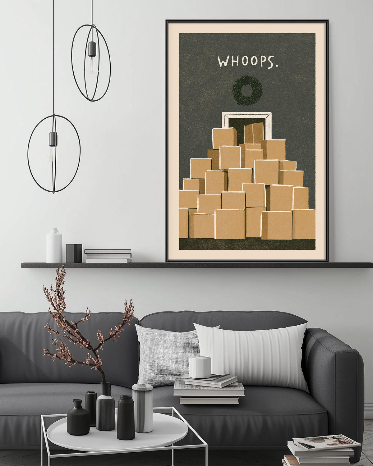 a modern living room with a gray sofa, a coffee table, and a large framed poster of a stack of boxes with the text "WHOOPS" above it.