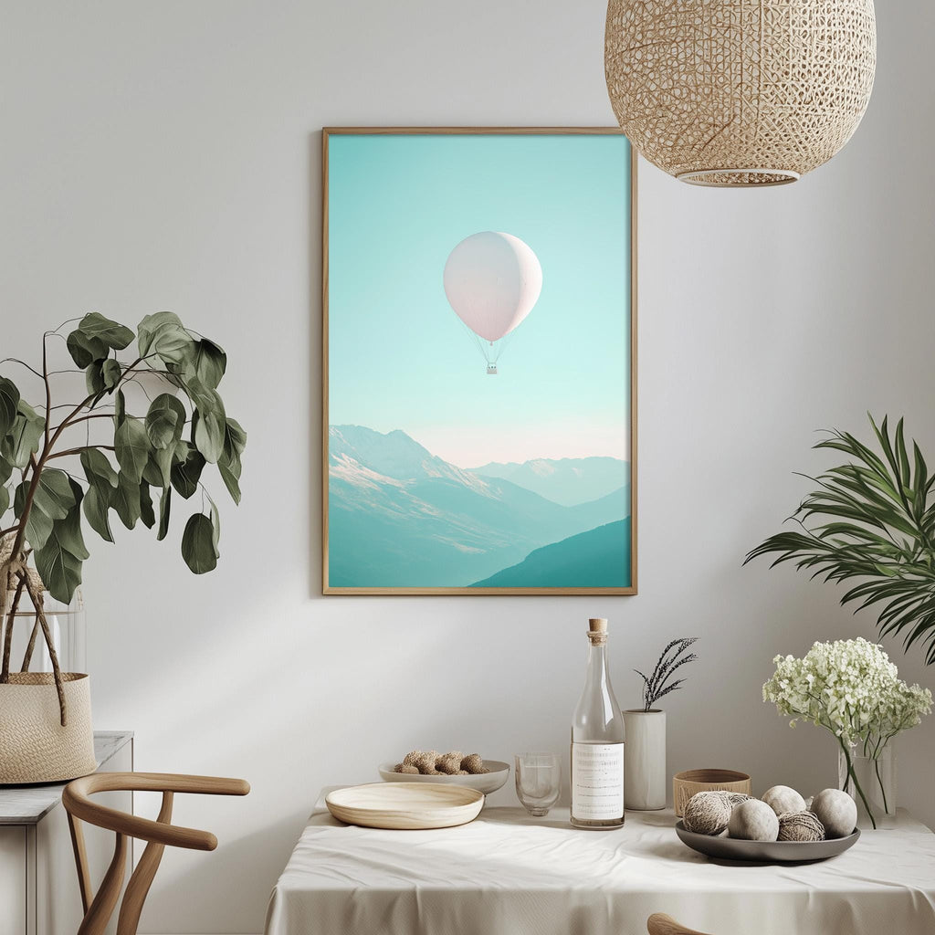 a dining table with a white tablecloth, a bowl of fruit, a bottle, and a vase with flowers. Above the table, there is a framed picture of a hot air balloon floating in the sky.