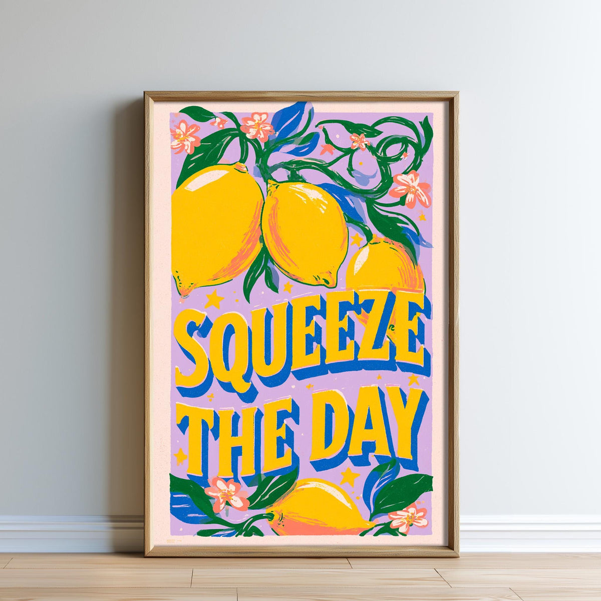 The image is a framed poster with a vibrant design featuring lemons and flowers. The text "SQUEEZE THE DAY" is prominently displayed in the center of the poster.