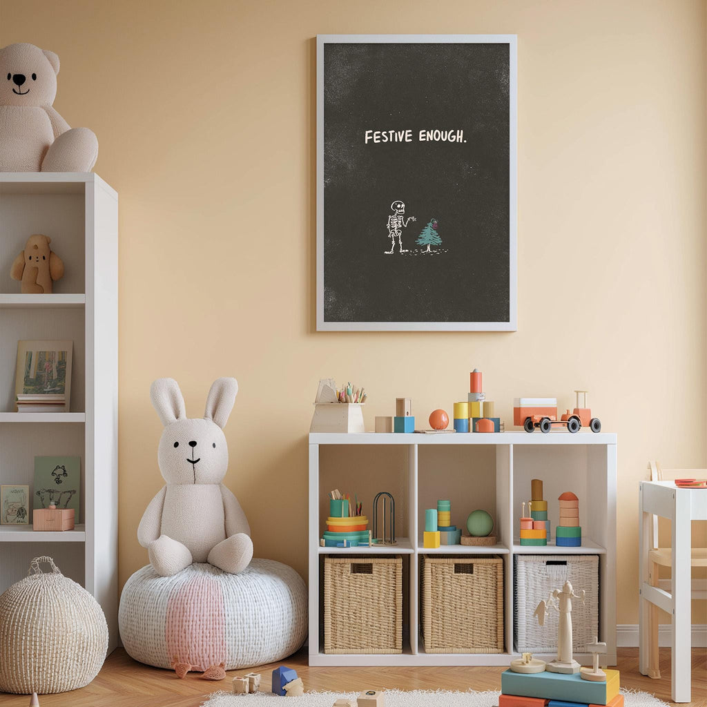 A cozy children's room with a white bookshelf, a stuffed rabbit, and a toy train. Above the bookshelf, there is a chalkboard with the text "FESTIVE ENOUGH."