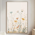 a living room with a large floral print hanging on the wall, featuring a field of flowers in various colors. The room has a white sofa, a wooden side table, and a lamp on a wooden cabinet.