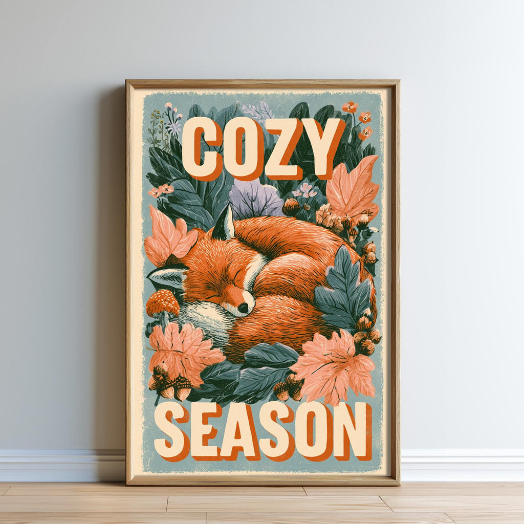 A framed poster with a sleeping fox surrounded by flowers and leaves, with the text "COZY SEASON" prominently displayed.