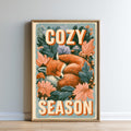 A framed poster with a sleeping fox surrounded by flowers and leaves, with the text "COZY SEASON" prominently displayed.