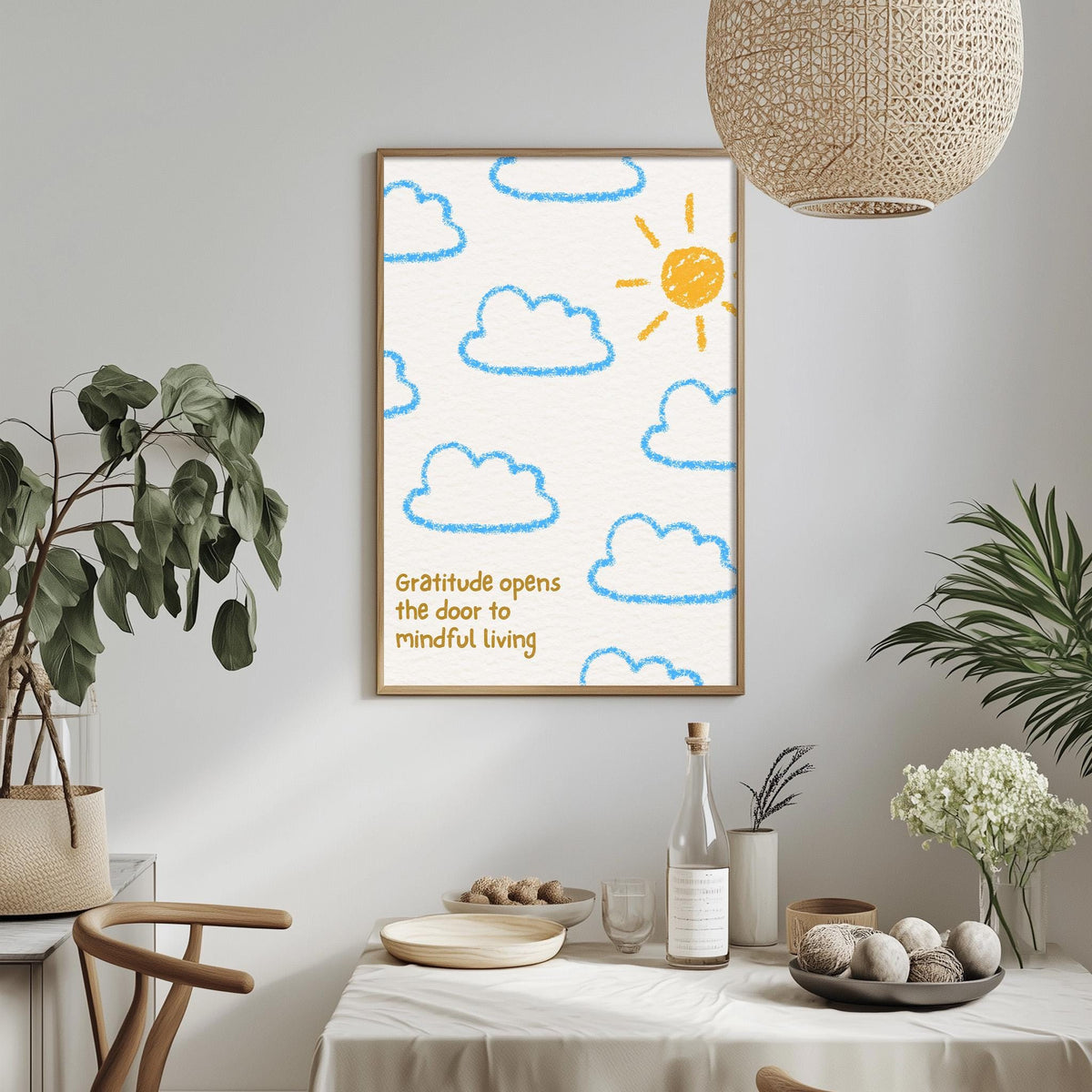 a framed poster with a drawing of clouds and a sun, hanging on a wall above a dining table with various items on it.