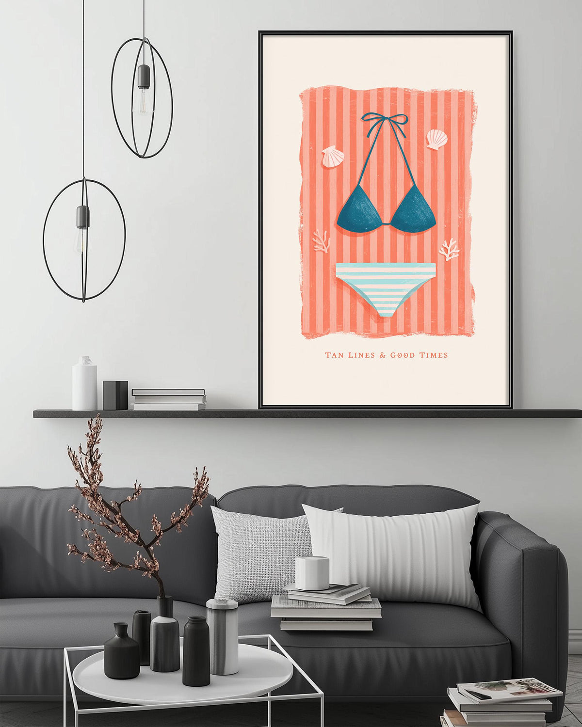a living room with a gray couch, a coffee table, and a framed poster of a bikini on the wall.