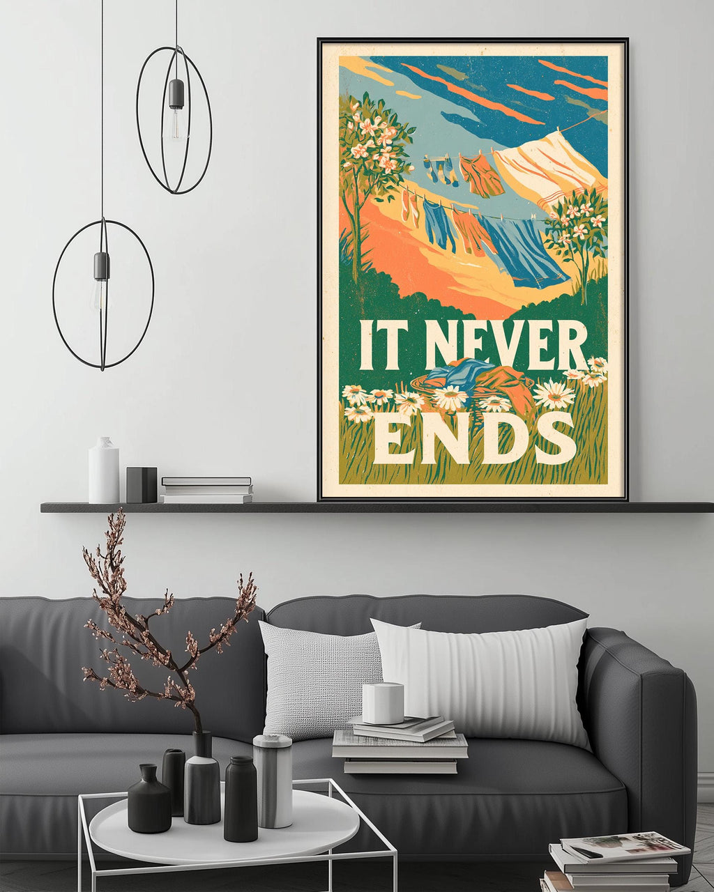 a large framed poster with a colorful illustration of mountains and flowers, hanging on a wall above a gray couch with a coffee table in front of it.