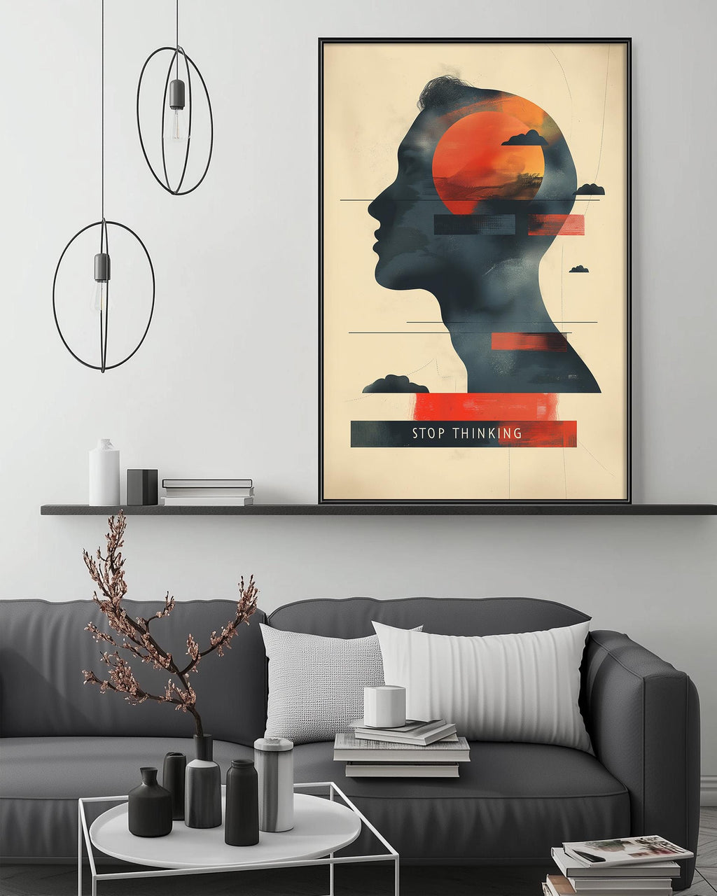 a modern living room with a gray sofa, a coffee table, and a framed poster on the wall. The poster depicts a silhouette of a person's head with a red circle and a cloud above it, along with the text "STOP THINKING".