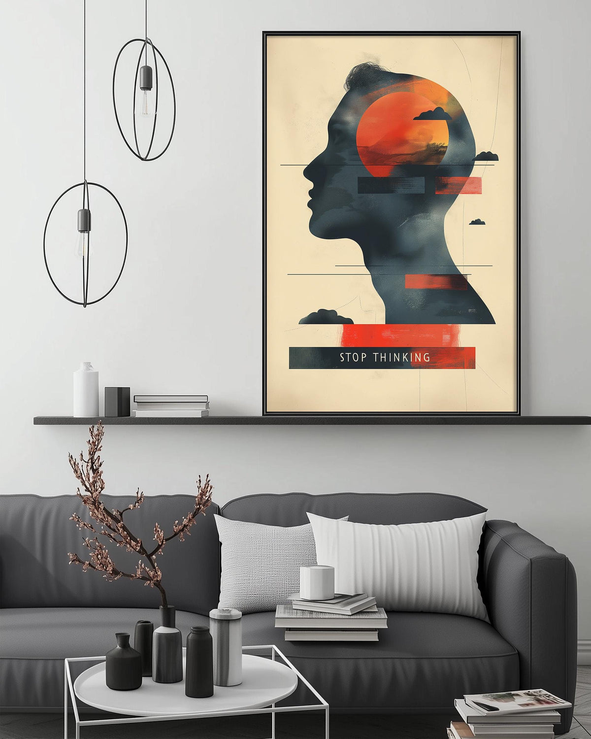 a modern living room with a gray sofa, a coffee table, and a framed poster on the wall. The poster depicts a silhouette of a person's head with a red circle and a cloud above it, along with the text "STOP THINKING".