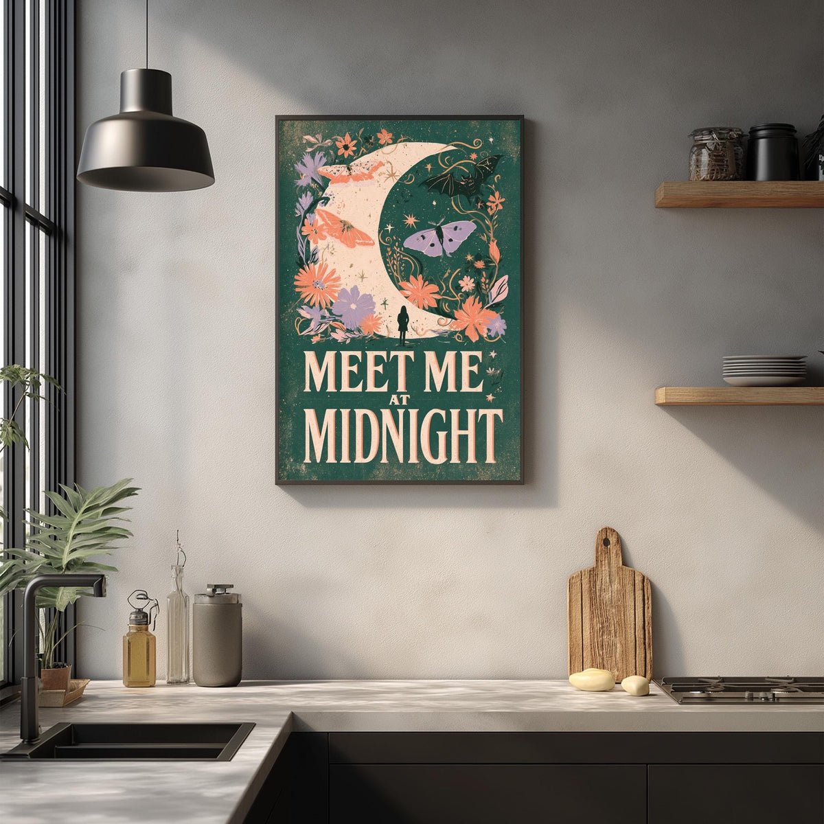 a kitchen counter with various kitchen items, such as a cutting board, a bottle, and a jar. Above the counter, there is a framed poster with a crescent moon and floral design, along with the text "MEET ME AT MIDNIGHT".