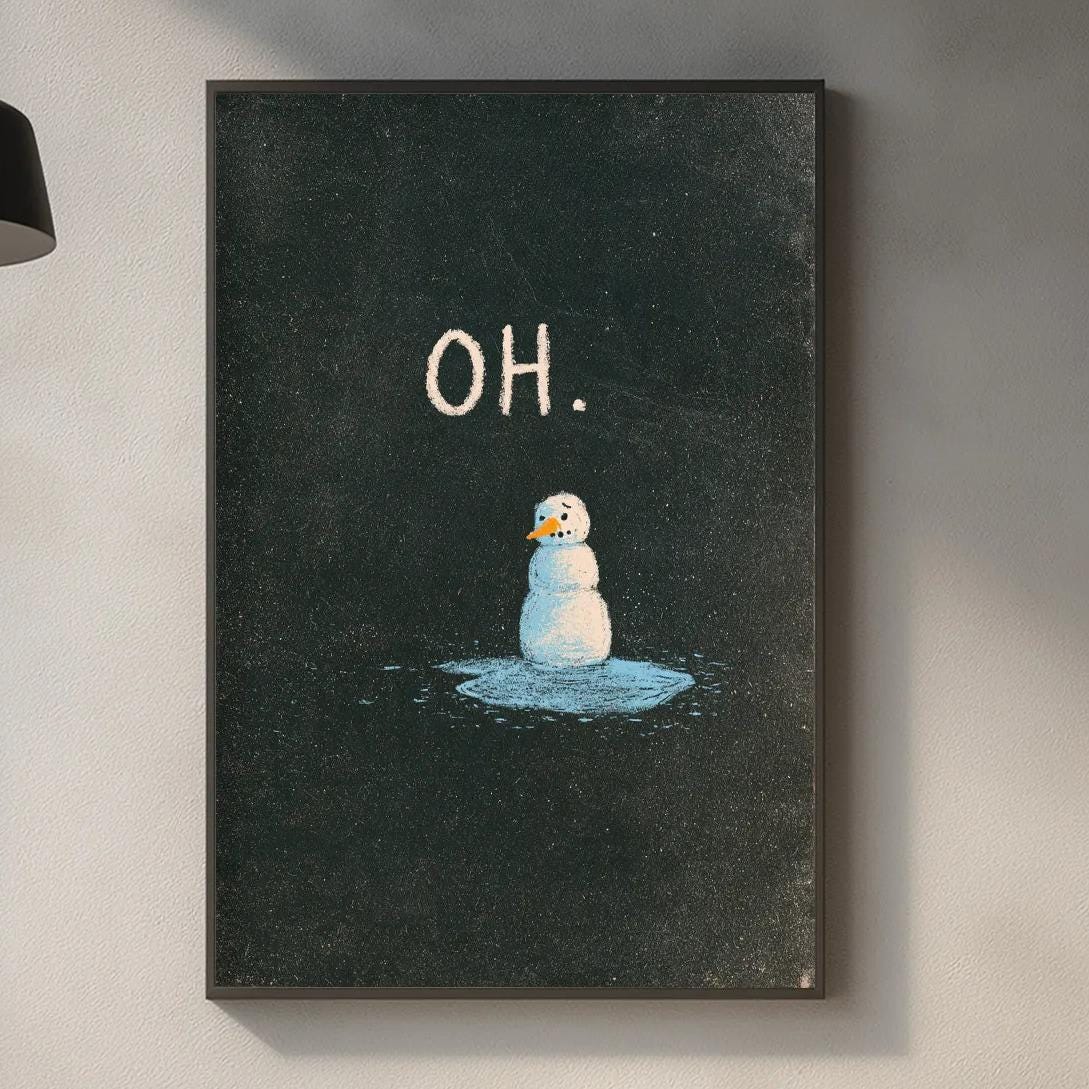 a kitchen counter with various kitchen items, including a cutting board, a soap dispenser, and a plant. Above the counter, there is a framed picture of a snowman with the word "OH" written on it.