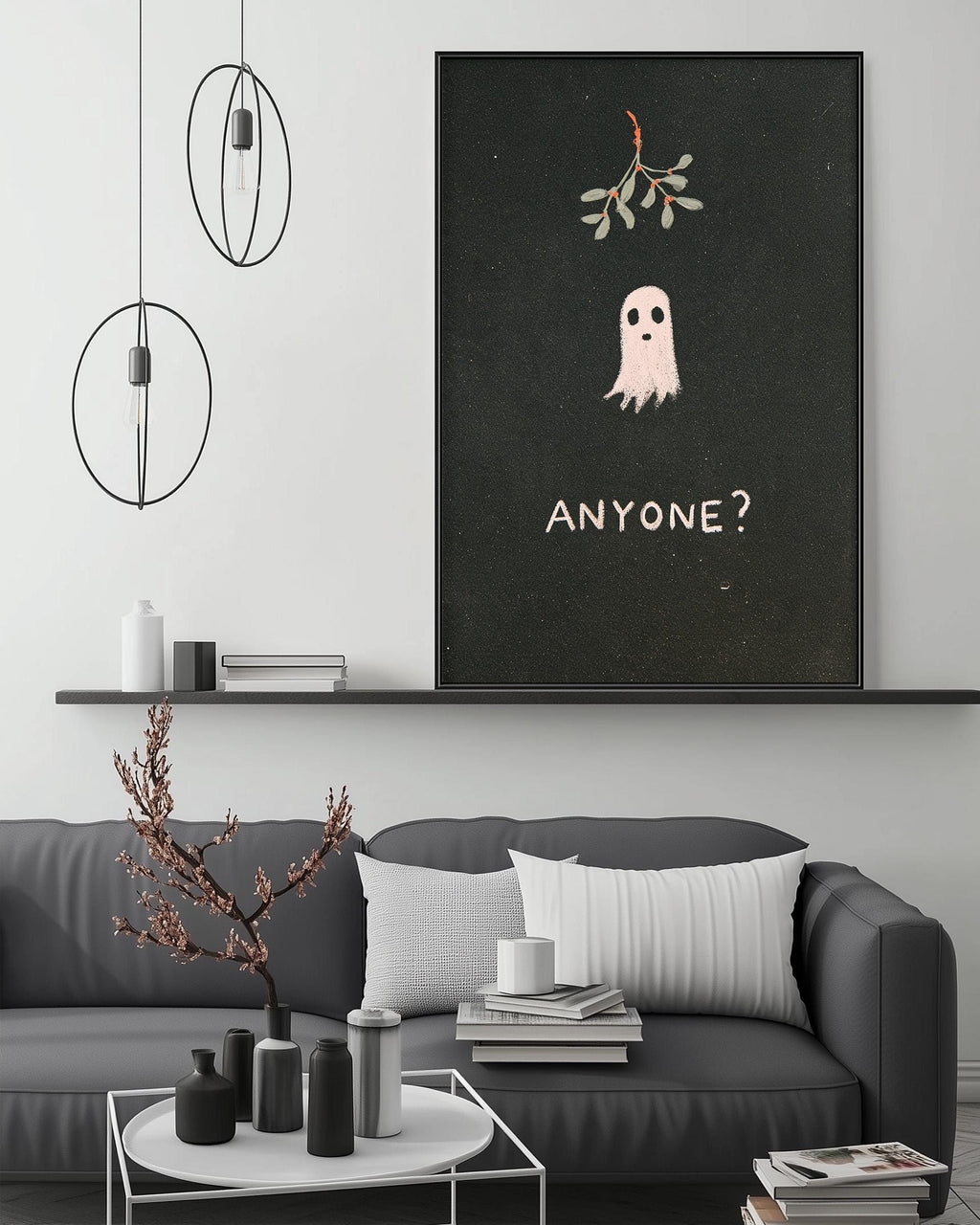 a living room with a gray couch, a coffee table, and a framed poster on the wall. The poster has a ghost and the text "ANYONE?"