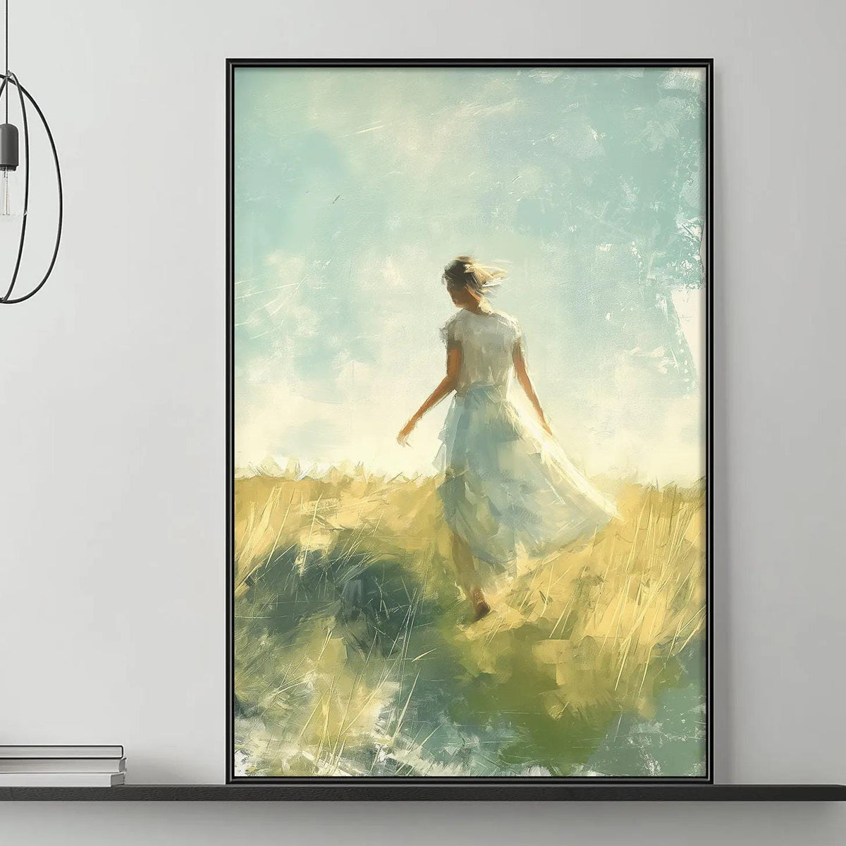 a large painting of a woman in a flowing white dress standing in a field, with a serene and peaceful atmosphere. The painting is displayed on the wall above a gray couch, which is adorned with decorative items such as a potted plant, vases, and books. The overall setting appears to be a cozy and inviting living space.