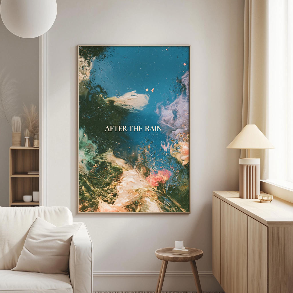 a large abstract painting hanging on a wall in a living room, with a white sofa and a wooden side table nearby.