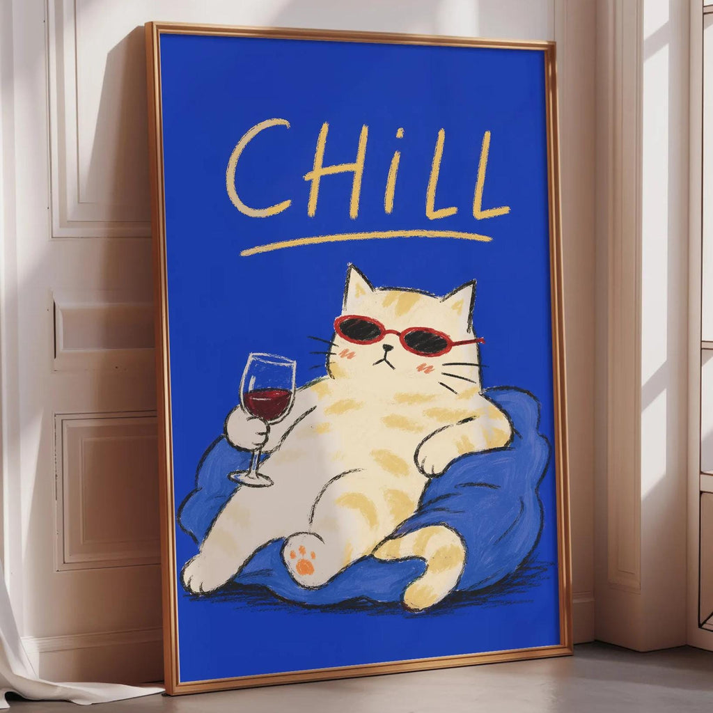 A framed poster with a cartoon cat wearing sunglasses and holding a glass of wine, sitting on a blue cushion.