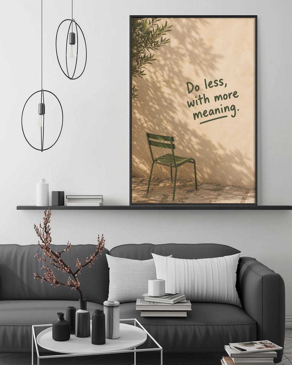 a living room with a gray sofa, a coffee table, and a framed poster with a green chair and the text "Do less, with more meaning."