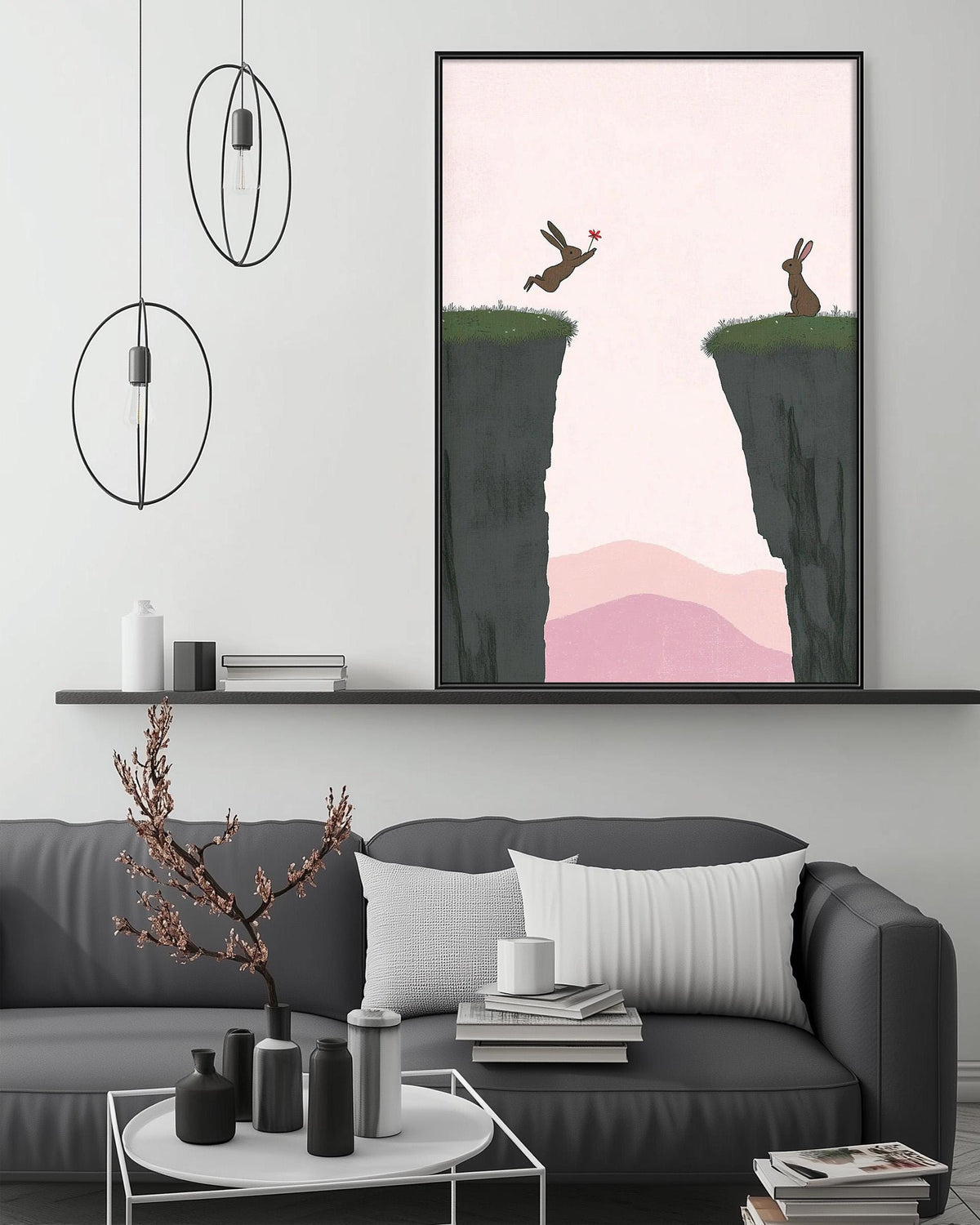 a living room with a gray sofa, a coffee table, and a large framed artwork depicting two rabbits jumping over a cliff.