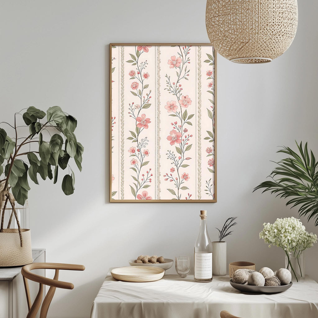 a dining table with a white tablecloth, a bowl of fruit, a bottle, and a vase with flowers. A framed floral print is hanging on the wall above the table, and a woven light fixture is hanging from the ceiling.