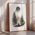 a framed artwork depicting a silhouette of a person standing in front of a forest of pine trees.