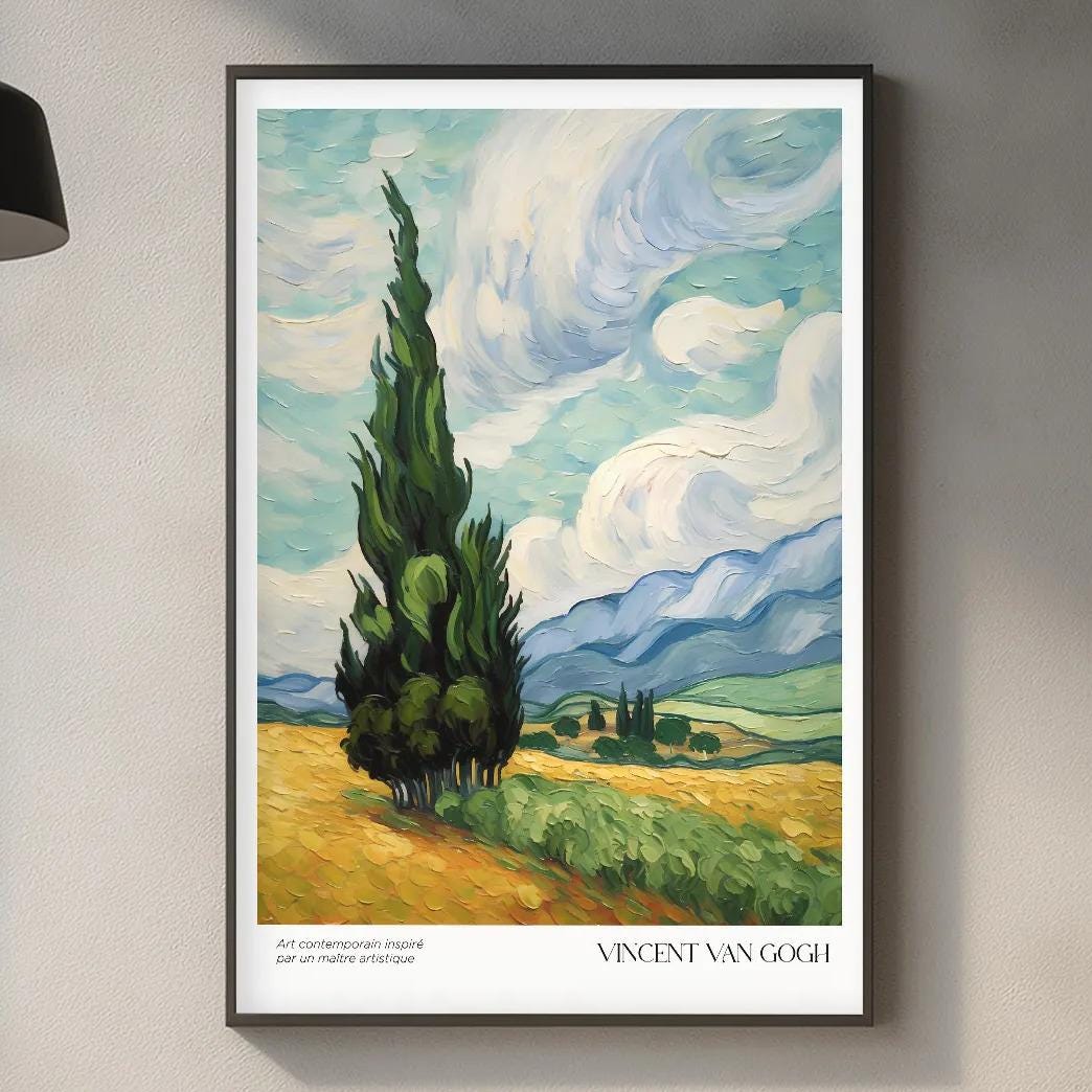 a framed painting of a landscape with a tall tree in the foreground, hanging on a wall above a kitchen counter with various kitchen items and a wooden cutting board.