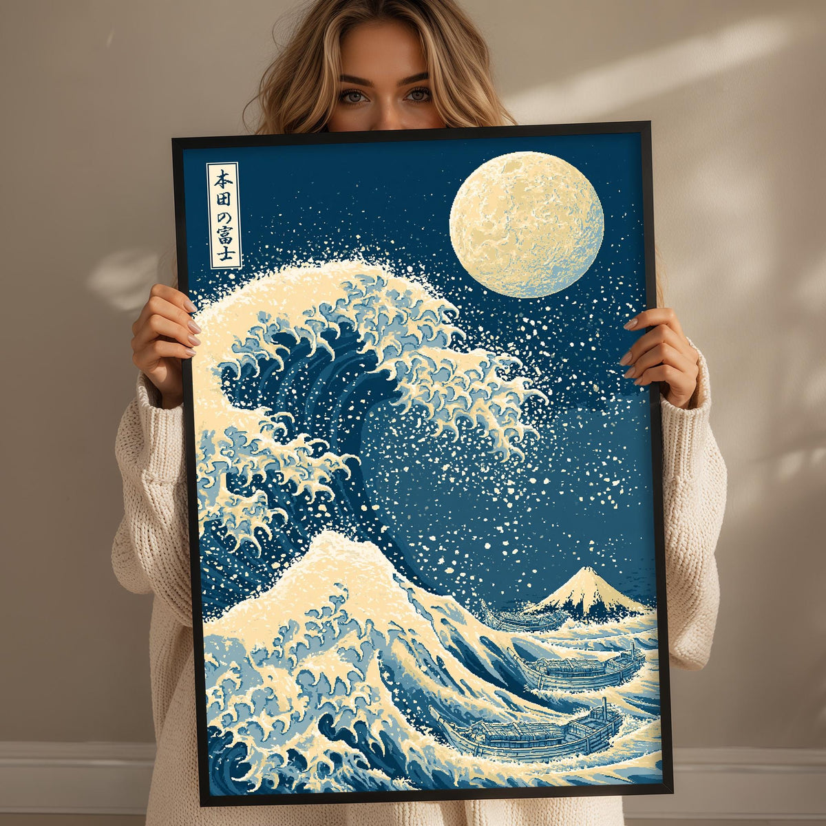 A woman holds up a framed print of a large, colorful wave with a moon in the background.