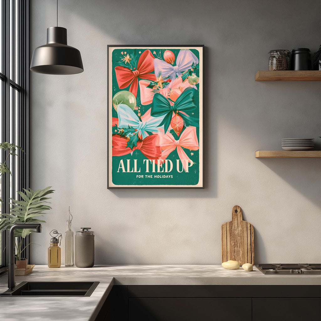 a kitchen counter with a framed poster of colorful bows hanging above it. The poster has the text "ALL TIED UP FOR THE HOLIDAYS" written on it.